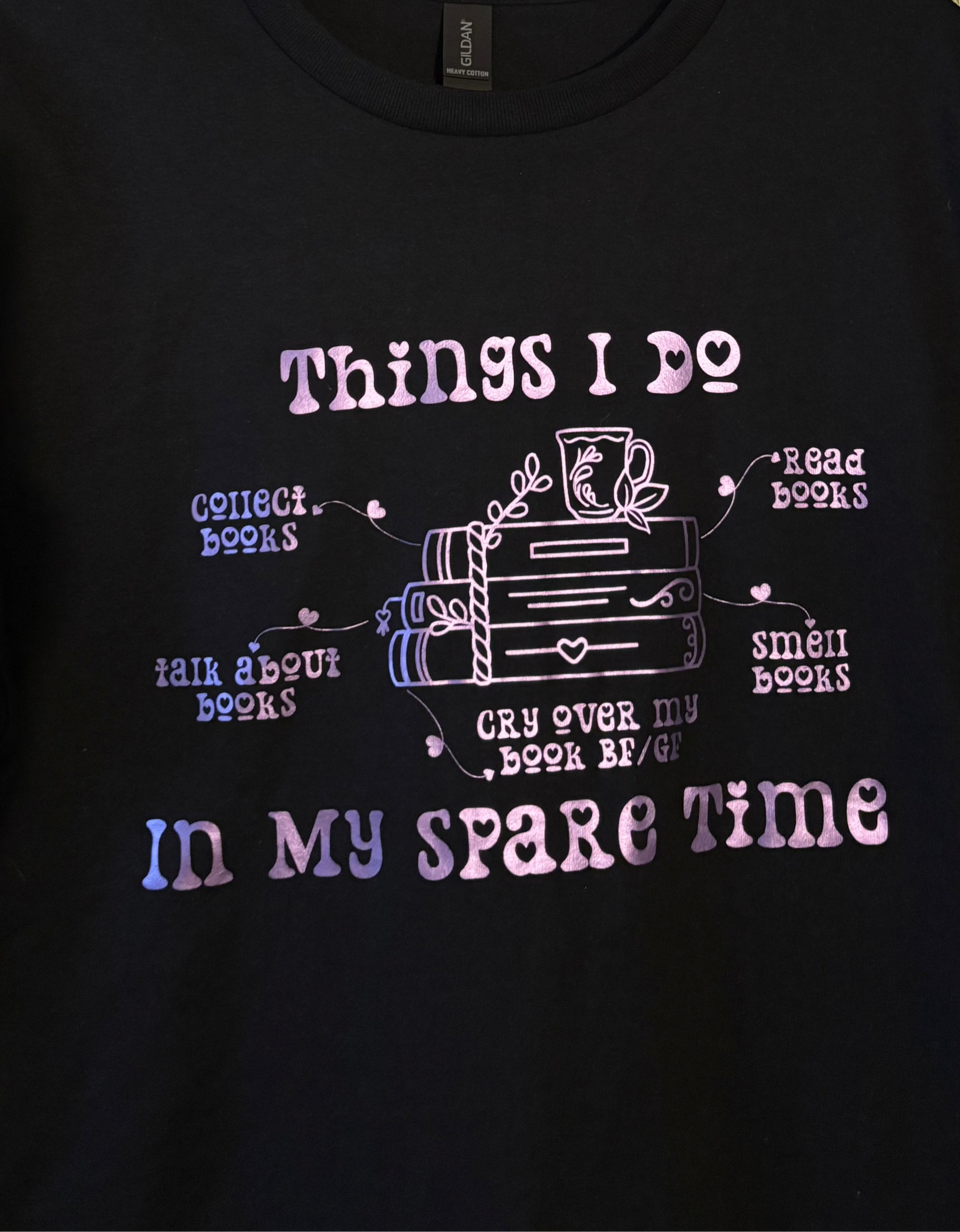 t-shirt with text reading Things I do in my spare time, featuring book-themed phrases: Collect books, Talk about books, Cry over my book BF/GF, Read books, and Smell books, with a cute tea cup on a stack of books.